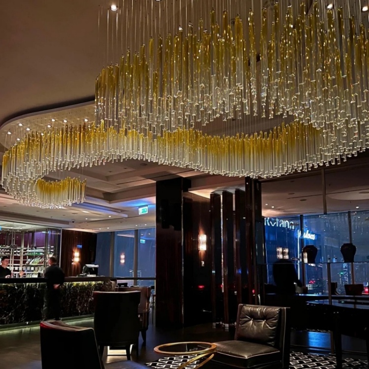 Overall view of the lounge golden glass rod wave chandelier
